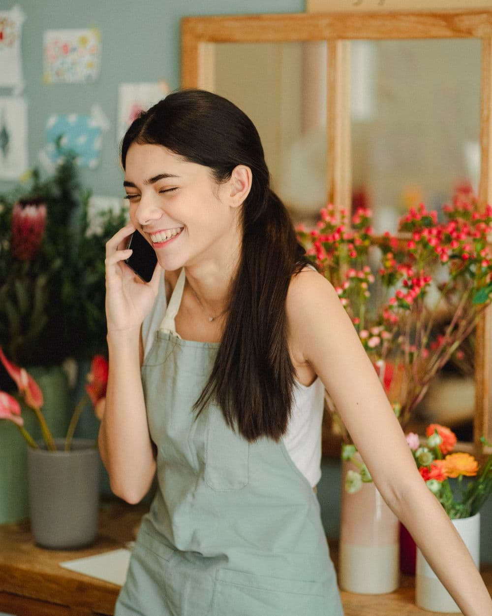 Florista contestando un pedido por teléfono en el taller
